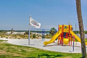 a playground with a slide and a flag at Pinnacle Port Beach Resort in Panama City Beach
