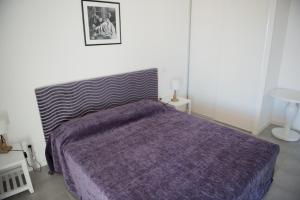 a bedroom with a bed with a purple blanket at Résidence Néméa l'Estacade in Capbreton