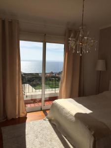 een slaapkamer met een bed en uitzicht op de oceaan bij OceanView Penthouse in Caniço