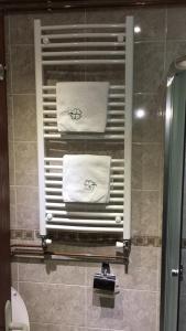 łazienka z prysznicem i ręcznikami na oknie w obiekcie Bellmatini w Belgradzie