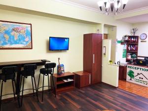 a room with a bar with stools and a refrigerator at Friendship Hostel & Tours in Yerevan