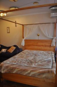a bedroom with a wooden bed with a canopy at Cozy apartments near the McDonalds in Kremenchuk