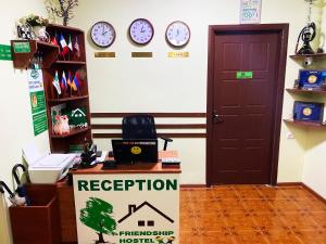 a reception room with clocks on the wall and a sign at Friendship Hostel & Tours in Yerevan