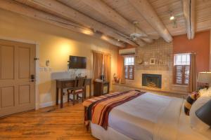 a bedroom with a bed and a desk and a television at Inn at Vanessie in Santa Fe