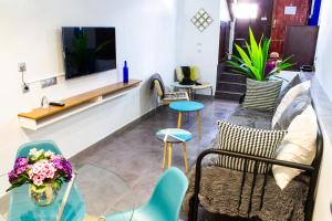 sala de estar con sofá, sillas y TV en Apartamento La Machacona TENERIAS, en Cáceres