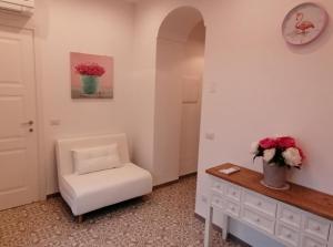 a room with a chair and a table with flowers at La Casa di Pitti in Anacapri