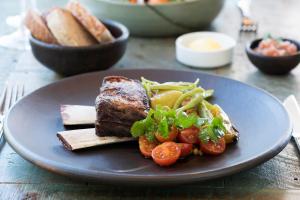 a plate of food with meat and vegetables on a table at Futangue Hotel & Spa in Lago Ranco
