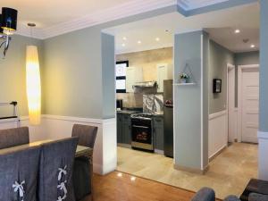 a kitchen and living room with a table and a stove at Sodic Westown Residence1-near Elnada hospital in ‘Izbat Yūsif Barrādah