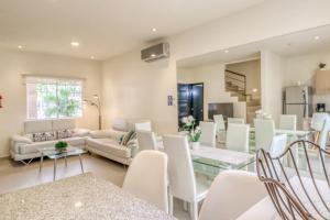 een woonkamer met witte stoelen en een eetkamer bij Selvanova Coto 4B, Villa Flamingos 437F in Playa del Carmen
