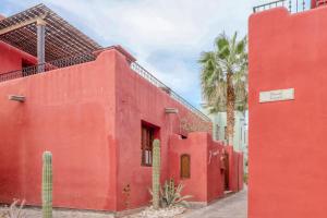 ein rotes Gebäude mit einer Palme dahinter. in der Unterkunft Casa la Bodega 533 at Founders in Nopoló