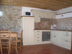 cocina con armarios blancos y mesa con microondas en Mas Taillet Le Camelia, en Prats-de-Mollo-la-Preste