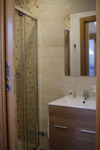 La salle de bains est pourvue d'une douche en verre et d'un lavabo. dans l'établissement Apartamento Noia Centro Izqda, à Noia