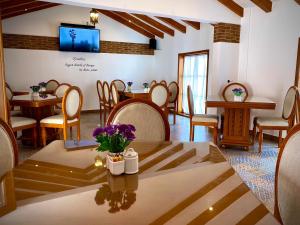 Habitación con mesa, sillas y TV. en La Alborada en Comitán de Domínguez