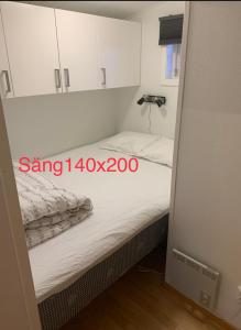 a small bedroom with a bed with white cabinets at Lillstugan Falköpingsvägen in Broddetorp