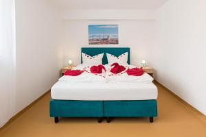 a blue and white bed with red roses on it at Hotel Ludwig in Munich