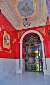 a room with a colorful door in a red wall at El Zaguán de la Plata in Fuente de Cantos