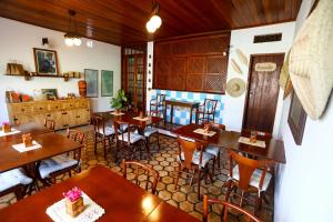 a restaurant with tables and chairs in a room at Hospedaria Tayrona in Lençóis