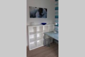 Zimmer mit einem Tisch und einer blauen Schale an der Wand in der Unterkunft Neues modern möbliertes Komfortappartement in Hilchenbach