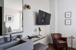 a bathroom with a sink and a chair and a mirror at Walker Hotel Tribeca in New York