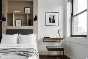 a bedroom with a bed and a chair and a window at Walker Hotel Tribeca in New York