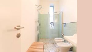 y baño con 2 aseos, lavamanos y ducha. en Secret garden in the heart of Isola, en Milán