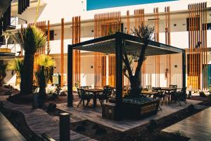 a pavilion with tables and trees in front of a building at HOTEL MINA REAL MATEHUALA in Matehuala