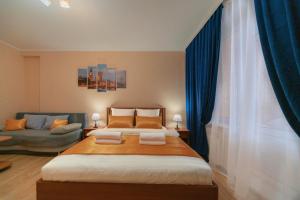 a bedroom with a large bed and a couch at Five Stars Argentina in Nizhnevartovsk
