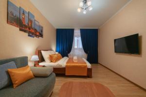 a room with a bed and a couch and a tv at Five Stars Argentina in Nizhnevartovsk