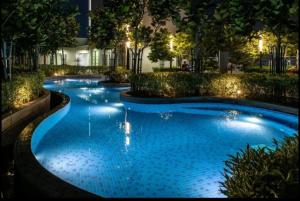 a swimming pool with blue water at night at The Robertson Bukit Bintang by Wowhome in Kuala Lumpur