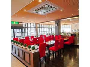 uma sala de jantar com cadeiras vermelhas e mesas num restaurante em Grand Park Hotel Kazusa / Vacation STAY 77395 em Kimitsu