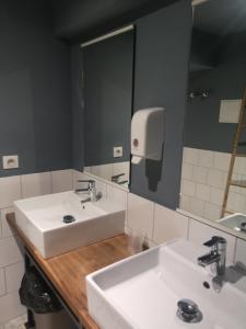 a bathroom with two sinks and a large mirror at Georges Hostel & Café in Sète