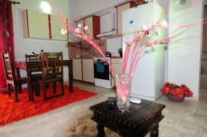 a kitchen with a table and a vase with pink flowers at Orizontes Suites XL in Kalamos