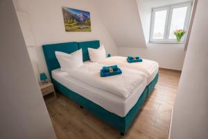 a bedroom with a bed with two blue towels on it at Hotel Ludwig in Munich