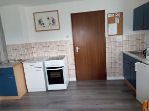 a kitchen with a white stove top oven next to a door at Ferienwohnung Schroiff in Simmerath