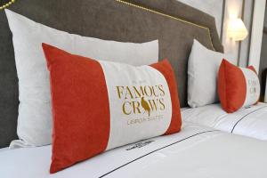 リスボンにあるFamous Crows Lisbon Suitesのベッドの上に置かれた白とオレンジの枕2つ