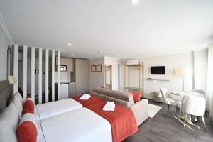 a hotel room with two beds and a television at Famous Crows Lisbon Suites in Lisbon