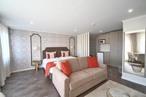 ein Schlafzimmer mit einem Bett und einer Couch in einem Zimmer in der Unterkunft Famous Crows Lisbon Suites in Lissabon