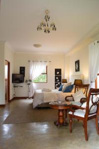 a bedroom with a bed and a chandelier at Hartley Manor Guest House in Muldersdrift