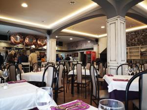 a restaurant with white tables and chairs and people at Hostal Los Hermanos in Baza