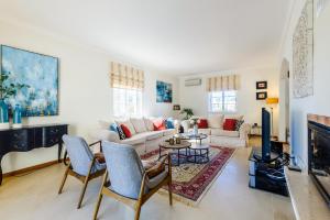 sala de estar con sofá y TV en Endless Summer Luxury Villa en Quinta do Lago