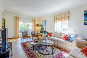 Endless Summer Luxury Villa في كينتا دو لاغو: غرفة معيشة مع أريكة وطاولة