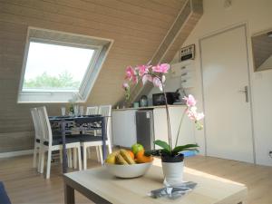 uma cozinha e sala de jantar com uma mesa com uma tigela de frutas em 13K Arz em Vannes
