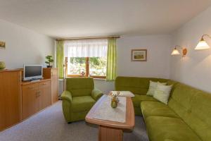 een woonkamer met een groene bank en een tafel bij Ferienwohnungen Beyer in Binz