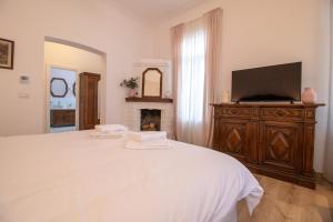 a bedroom with a white bed and a fireplace at Seven Cafe and Hotel in Pogradec
