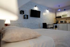 1 dormitorio con cama y pared de ladrillo en Studio Banovac en Dubrovnik