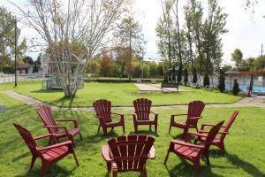 a group of chairs sitting in the grass in a park at Colonial Resort-1000Islands in Gananoque