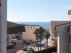 Blick auf eine Stadtstraße mit Palmen und das Meer in der Unterkunft Casa Fontana in Cala Ratjada