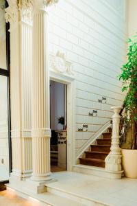 a hallway with white columns and a staircase at Heirloom Hotels - The Mansion in Ghent