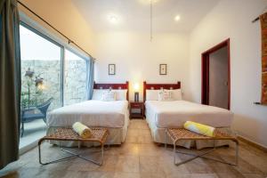 2 camas en una habitación con ventana grande en Condo Magia - 2 Bedroom on Mamitas Beach at Magic Paradise, en Playa del Carmen