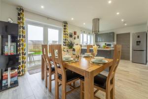 a kitchen and dining room with a wooden table and chairs at Beacon View in St. Agnes 